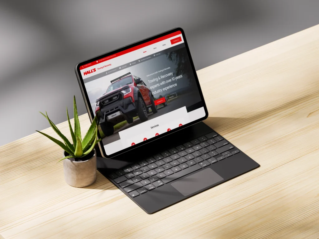 A clean image of Hall's Towing & Recovery website displayed on a tablet with a keyboard.